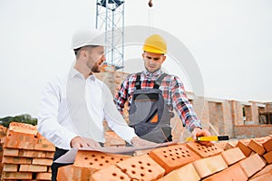 Structural engineer and foreman worker discuss, plan working for the outdoors building construction site