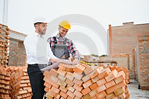 Structural engineer and foreman worker discuss, plan working for the outdoors building construction site