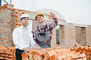 Structural engineer and foreman worker discuss, plan working for the outdoors building construction site