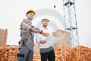 Structural engineer and foreman worker discuss, plan working for the outdoors building construction site