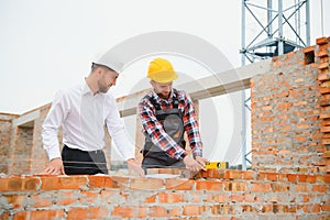 Structural engineer and foreman worker discuss, plan working for the outdoors building construction site