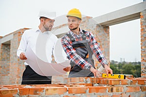 Structural engineer and foreman worker discuss, plan working for the outdoors building construction site