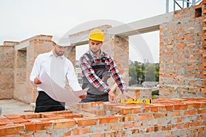 Structural engineer and foreman worker discuss, plan working for the outdoors building construction site