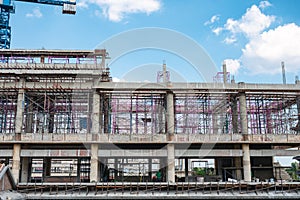 Structure of large building with worker working, crane and scaffold in construction site