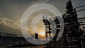 Structure of oil industry backlit by sunset