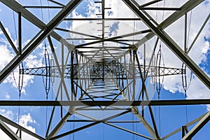 Structure of a powerline with electric wires against a blue sky on a sunny day