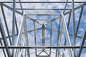 Structure of steel roof frame with blue sky and clouds