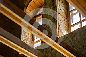 Structures and windows of a wooden ecohouse with clay plaster. Bottom view