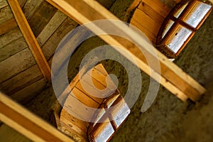 Structures and windows of a wooden ecohouse with clay plaster. Bottom view