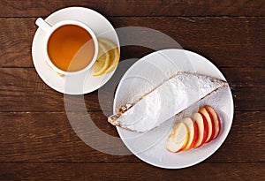 Strudel with apples and a cup of tea with lemon