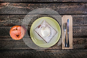 Strudel with cherry and vanilla ice cream, served on the ceramic plate with the cutlery and the glass of beverage.