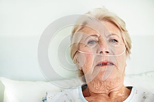 Struggling to breath - Senior Health. Ailing senior woman wearing a nasal cannula looks for hope - Copyspace.