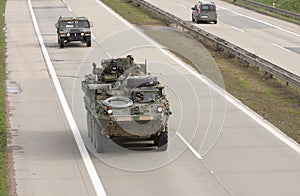 Stryker,wheeled armored vehicle drives on highway .