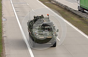 Stryker, wheeled armored vehicle drives on highway . photo