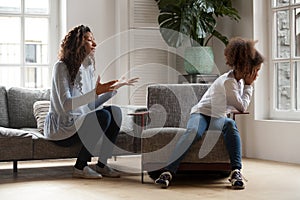 Stubborn african kid ignoring mom scolding, parent and child con