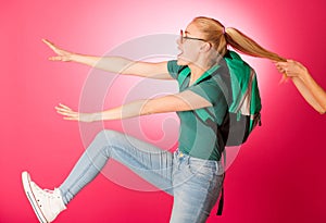 Stubborn, angry schoolgirl resisting to go to school.