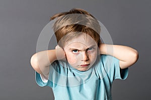 Stubborn kid with an attitude ignoring parents scolding, blocking ears