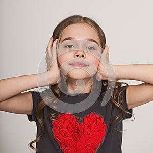 Stubborn little girl blocking her ears with hands