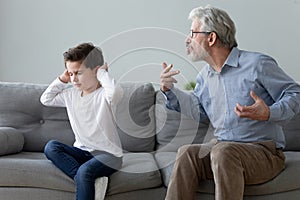 Stubborn naughty grandson ignoring strict annoyed grandfather