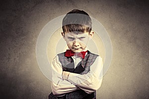 Stubborn,sad,upset little boy,child over grey backgro photo