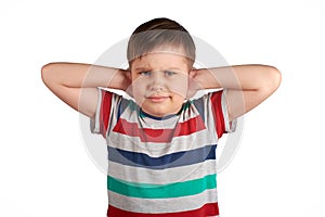 Stubborn young kid, covering his closed ears,ignores what they say, asking for silence, isolated on white background