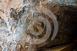 The stucco of ancient reclining Buddha at the Khao Ngu Cave in T