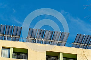 Stucco facade building with cream and beige exterior with metal rooftop awnings in midday sun in downtown city