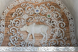 Stucco of a zodizac cow, classical Thai style on a temple wall photo