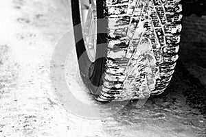 Studded winter tires on car wheel in  snow.