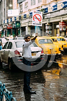 Student activists peacefully demanding for ` Silence, No Horn` on the road with yellow taxis in background in Kolkata, India