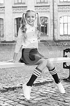 Student adorable child in formal uniform relaxing outdoors. Perfect schoolgirl relaxing between classes. Life balance