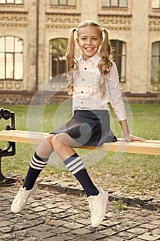 Student adorable child in formal uniform relaxing outdoors. Perfect schoolgirl relaxing between classes. Life balance
