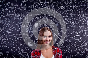 Student against a big blackboard with mathematical symbols