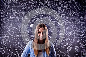 Student against a big blackboard with mathematical symbols