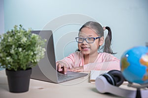 Student Asian kids girls wearing glasses smile happy use laptop learning from home in the room personal. Concept learning online