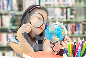 Student asian smiling child studying and education Earth Globe in library, select focus.