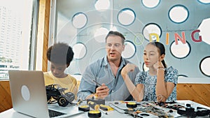 Student asking teacher about code and pointing at laptop screen. Edification.