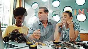 Student asking teacher about code and pointing at laptop screen. Edification.