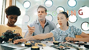 Student asking teacher about code and pointing at laptop screen. Edification.