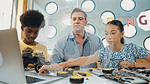 Student asking teacher about code and pointing at laptop screen. Edification.