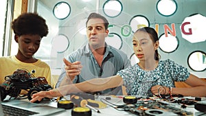 Student asking teacher about code and pointing at laptop screen. Edification.