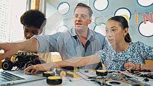 Student asking teacher about code and pointing at laptop screen. Edification.