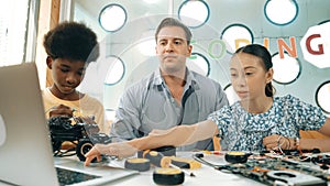 Student asking teacher about code and pointing at laptop screen. Edification.