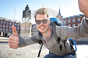 Student backpacker tourist taking selfie photo with mobile phone outdoors