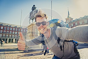 Student backpacker tourist taking selfie photo with mobile phone outdoors