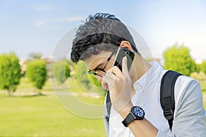 Student with bag talking in phone,outdoor.