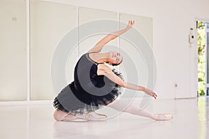 Student ballerina dancer dancing, girl practicing a dance routine and getting ready for a performance at a studio alone