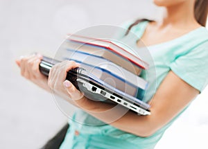 Student with books, computer and folders