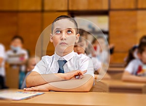 Student boy doing test at the elementary school during the lesson
