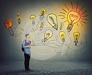 Student boy holding books and backpack imagining bright lightbulbs on the wall. Smart and ingenious teen guy has different